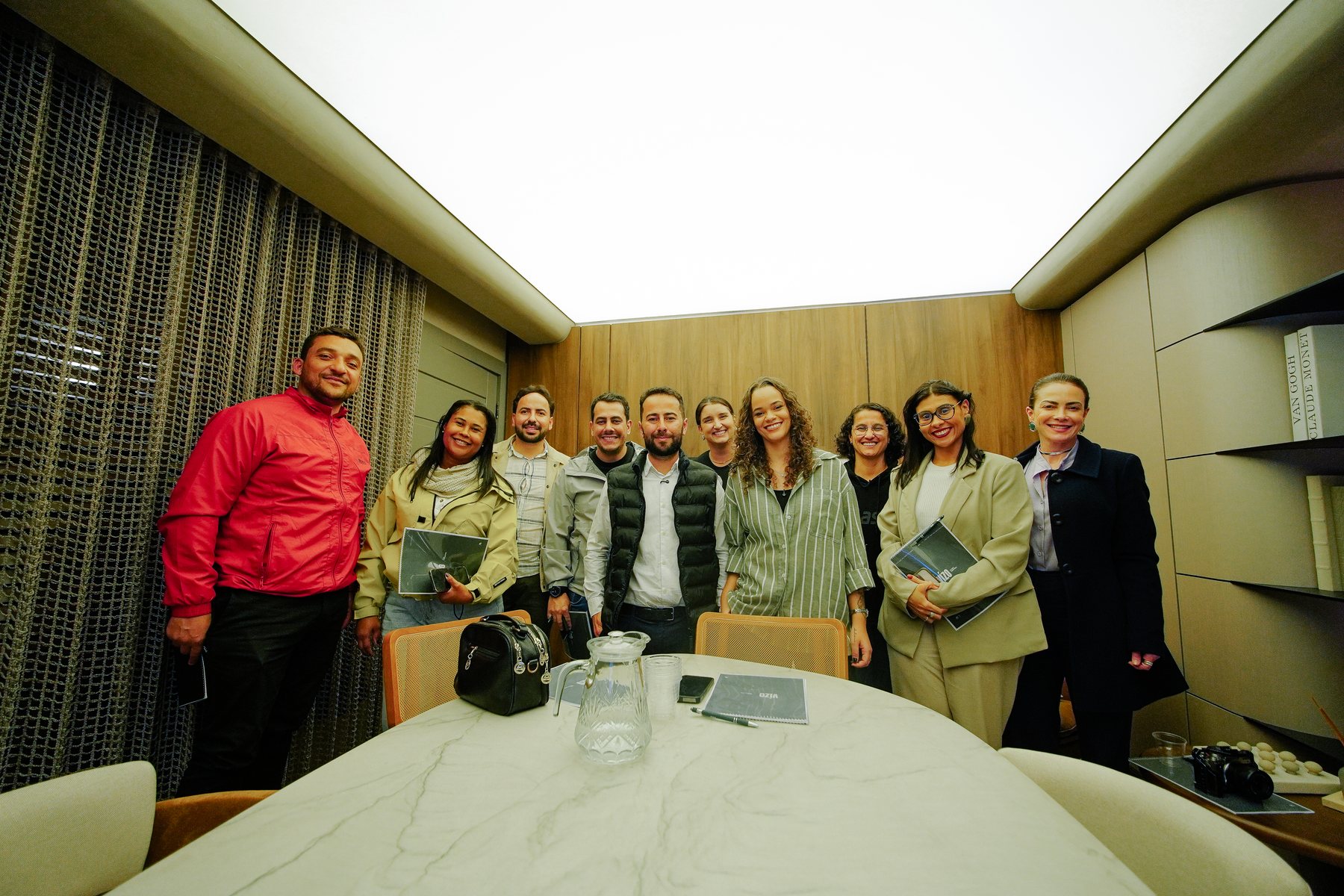 Foto de grupo com os participantes do workshop e a facilitadora, sorrindo na sala de reunião.